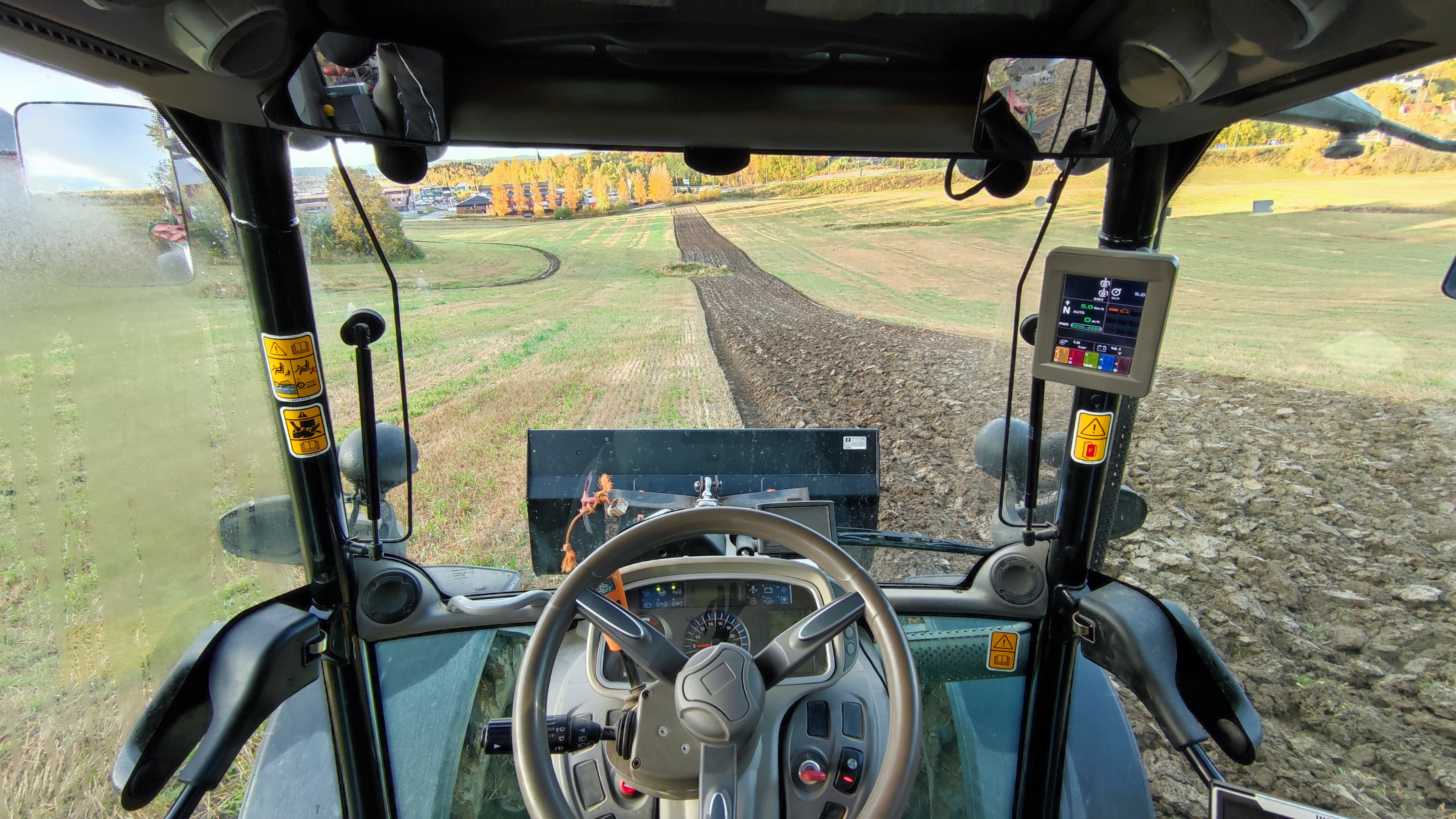 View from inside tractor while working fields in Norway